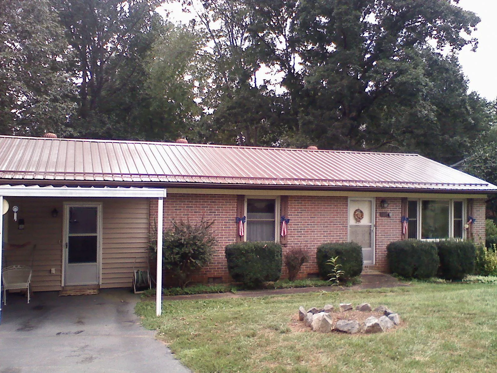 Bronze metal roof and carport on a brick ranch home — Roof Repair work by our crew in Spring